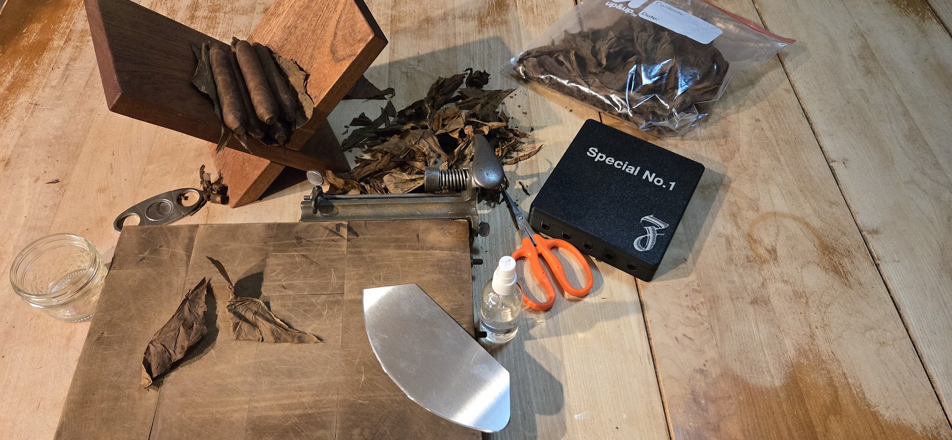 Cigar rolling tools including tobacco leaf, a cutter, and a Special No.1 mold box